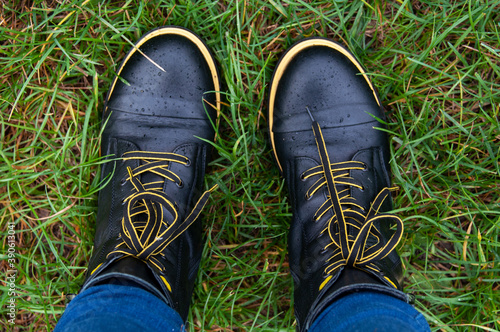 Casual black yellow boots standing outdoor on grass