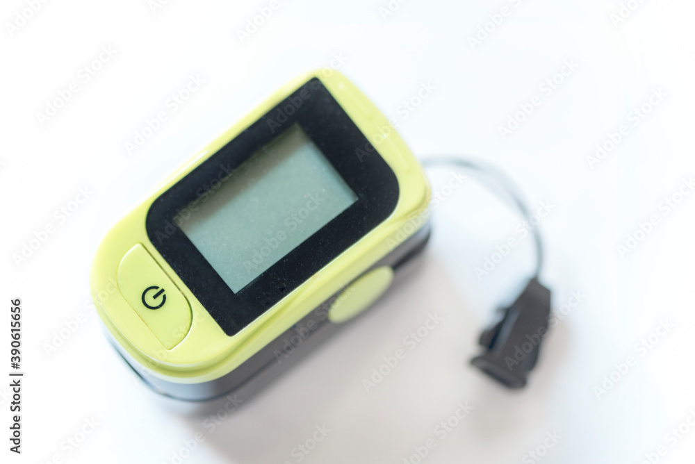 Black and green colored pulse oximeter on a white background, isolated, close up Black and green colored pulse oximeter on a white background, isolated, close up