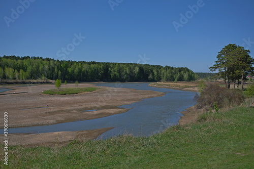 shallow river in early spring in the village of russia