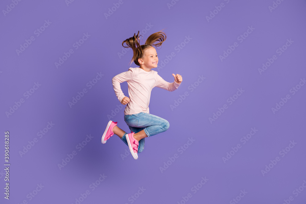 Full size profile side photo of brown haired tails little girl wear jeans sweater jump run isolated on purple color background