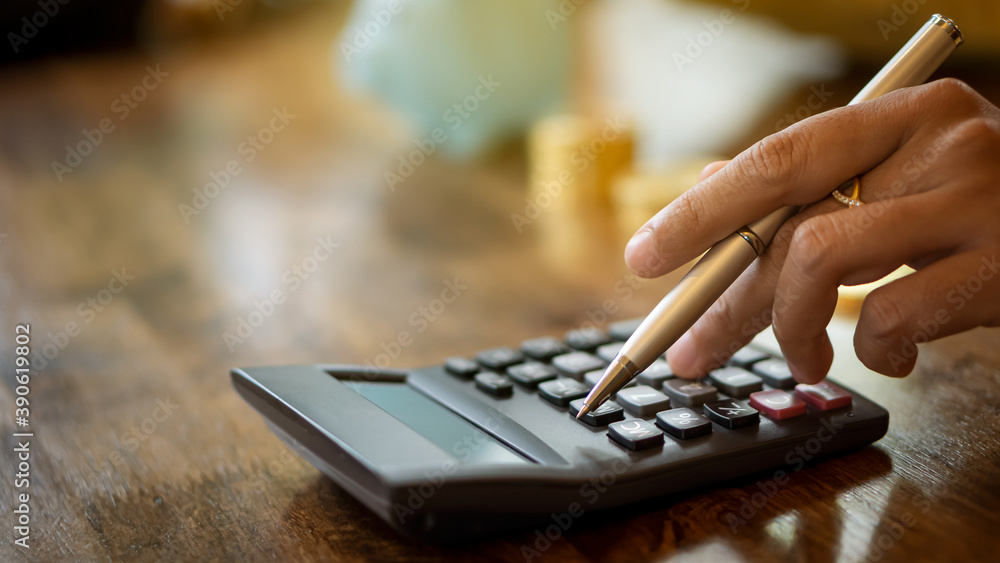 A business woman holding a pen and pressing a calculator to calculate the pattern A business woman holding a pen and pressing a calculator to calculate the pattern