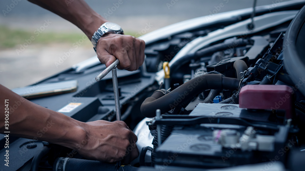 A car mechanic working in a car repair professional mechanic car maintenance service hand holding a wrench