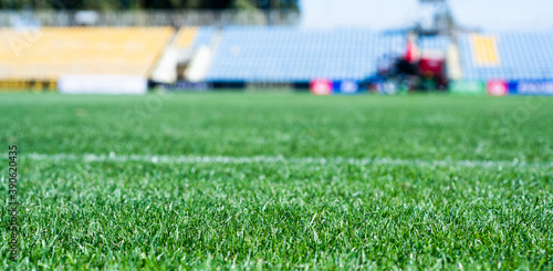 green grass on outdoor stadium, selective focus. sport and games. healthy lifestyle. playing football field. gridiron with markings. stadium arena soccer field