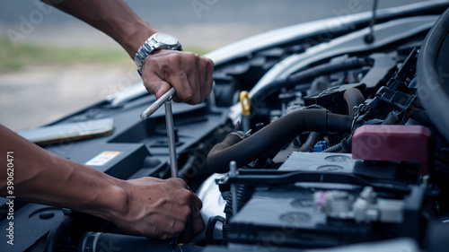 A car mechanic working in a car repair professional mechanic car maintenance service hand holding a wrench