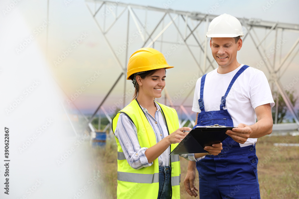 Fototapeta premium Professional engineers working on installation of electrical substation outdoors