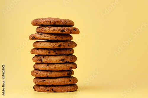 Pile of chocolate chip cookies on yellow backgreound