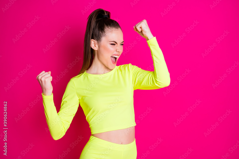 Photo of astonished pretty young woman stand fists up yell dress sport suit isolated on vibrant shine pink color background Photo of astonished pretty young woman stand fists up yell dress sport suit isolated on vibrant shine pink color background
