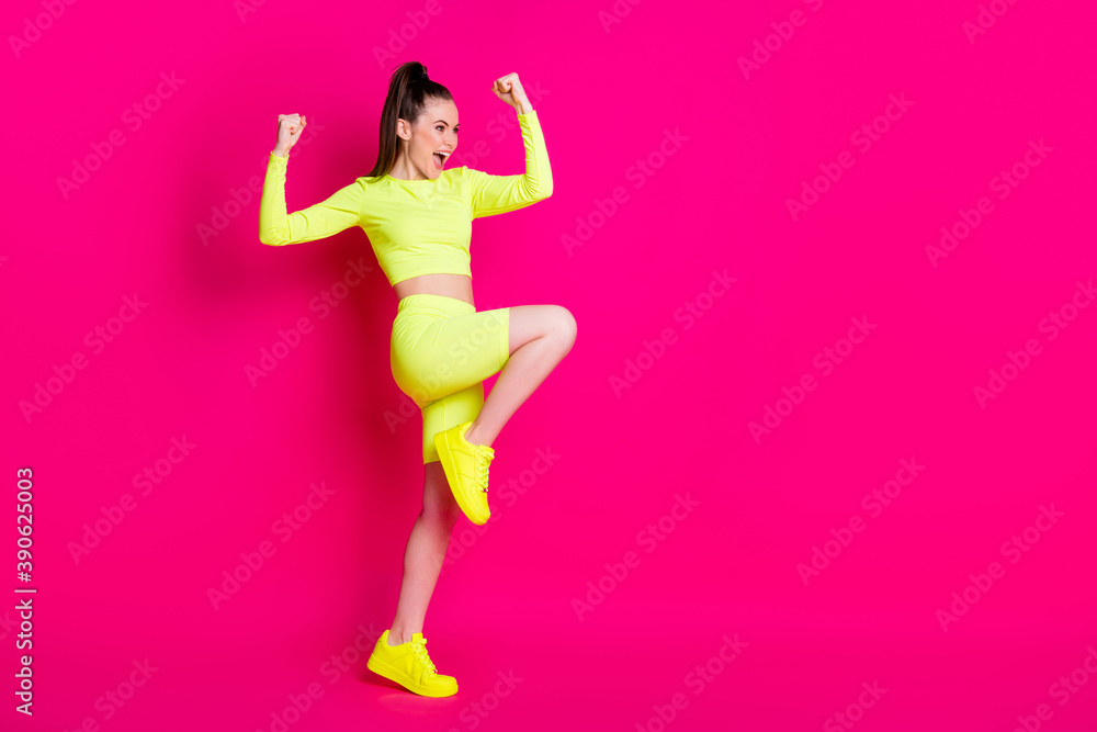 Full size profile photo of astonished young lady stand fists up yell look empty space dress sport suit isolated on pink color background
