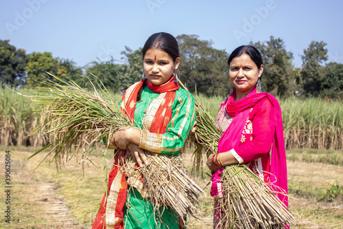 Canvas Print Mother and daughter holding paddy in india. . High quality photo