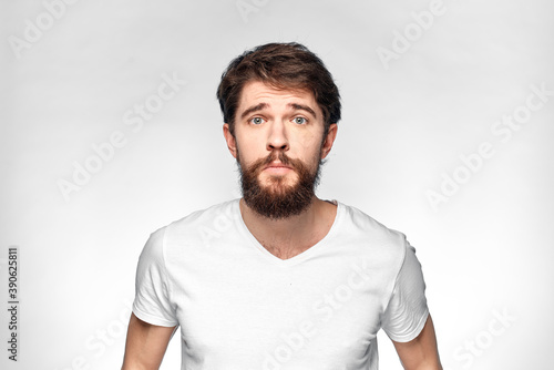cheerful emotional bearded man gesturing with his hands close-up light background © SHOTPRIME STUDIO
