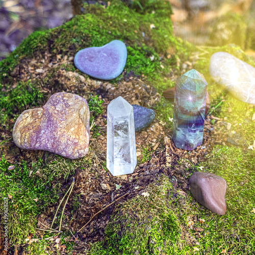 Gemstones fluorite, quartz crystal and various stones. Magic rock for mystic ritual, witchcraft Wiccan and spiritual healing on stump in forest. Meditation reiki. Ritual for love. Backlight