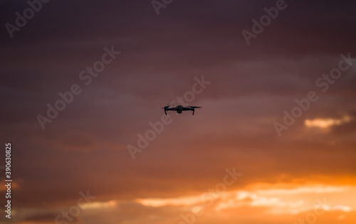 drone quadcopter with digital camera at beautiful sunrise sky. © The Len