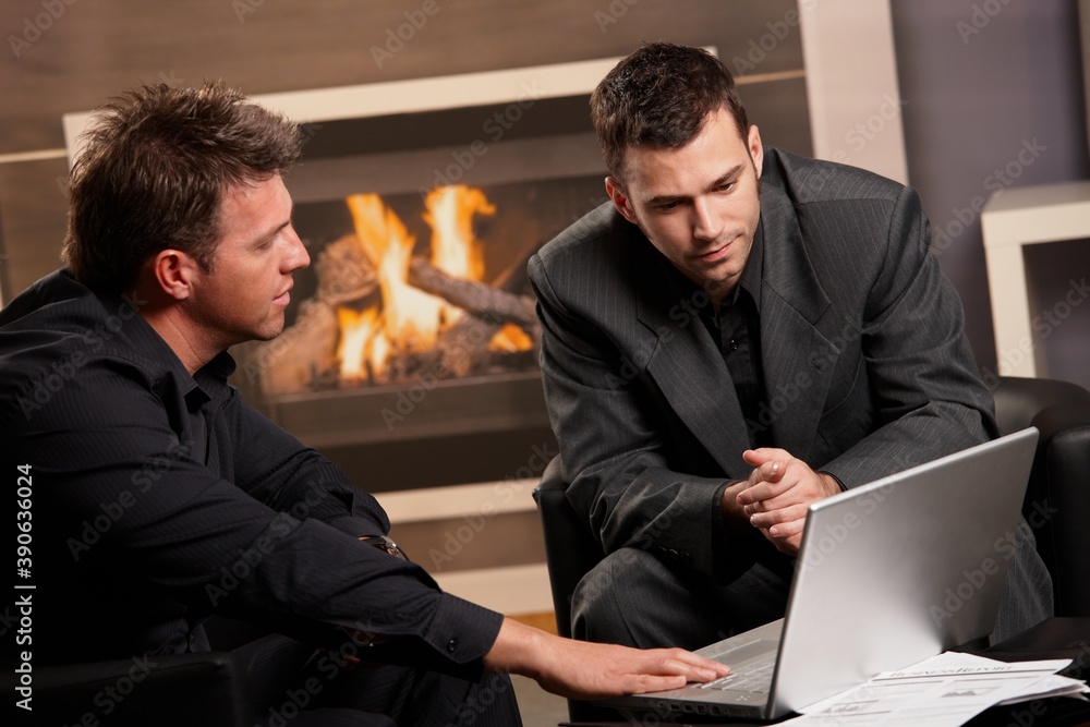Businessmen working together at fireplace, getting financial advice, looking at laptop computer. Businessmen working together at fireplace, getting financial advice, looking at laptop computer.