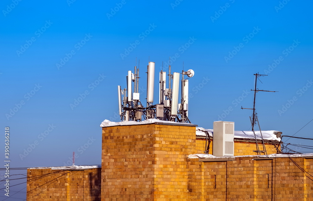 Telephone repeater on the roof of a house against the blue sky in winter Telephone repeater on the roof of a house against the blue sky in winter
