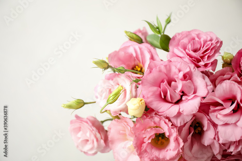 Beautiful pink Eustoma flowers on light background  closeup