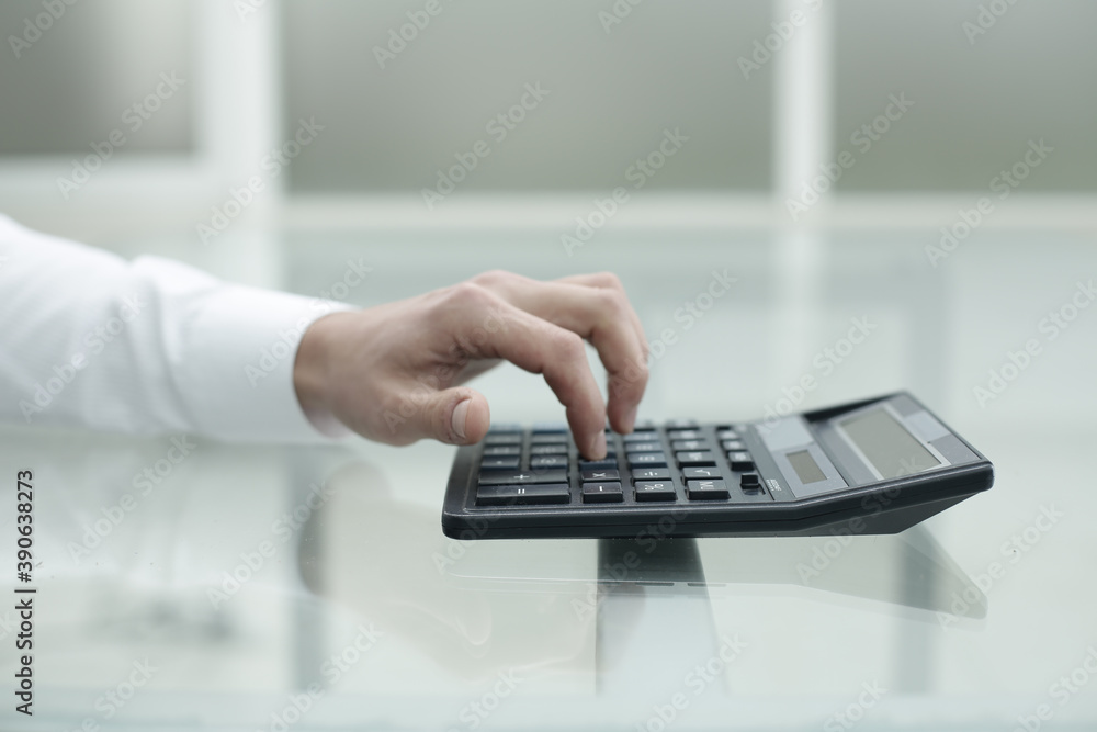 The hand of an office worker is counting on a calculatorм The hand of an office worker is counting on a calculatorм