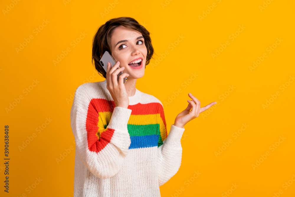 Photo of charming girl hold telephone look empty space wear striped sweater isolated yellow color background Photo of charming girl hold telephone look empty space wear striped sweater isolated yellow color background