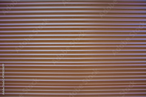Texture of corrugated wall made of brown metal.