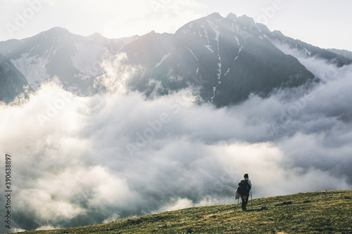 Woman hiking at sunset mountains with heavy backpack Travel