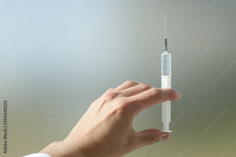 Doctor's hand holds a syringe with a needle in which the medicine is drawn Doctor's hand holds a syringe with a needle in which the medicine is drawn