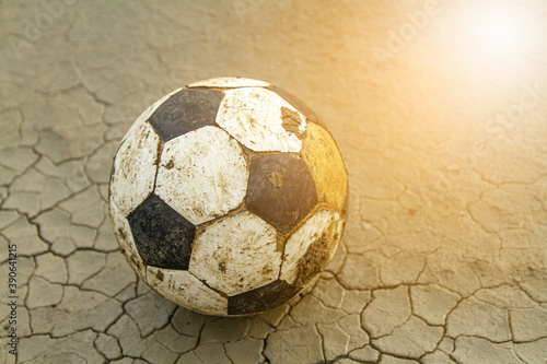 Fototapeta Naklejka Na Ścianę i Meble -  Closeup shot of old football soccer on ground and sun light