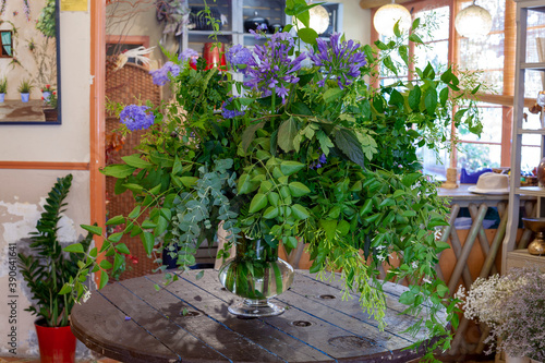 Fototapeta Naklejka Na Ścianę i Meble -  flower arrangement with purple flowers, green leaves and eucalyptus on wooden table