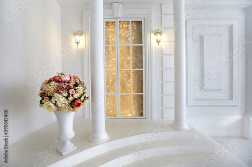 Bright interior of the photo Studio with a large window, columns, high ceiling, white marble floor in the classic style of ancient architecture