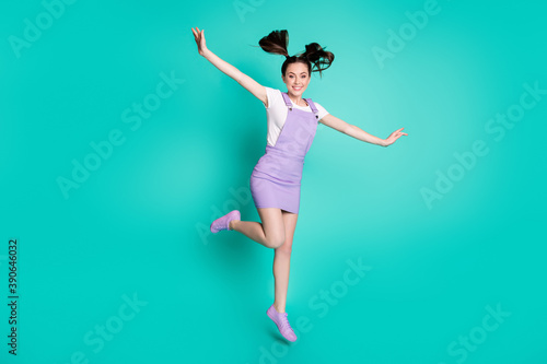 Fototapeta Naklejka Na Ścianę i Meble -  Full length body size photo of girl with tails pretending flying plane with wings wearing overall isolated on vivid teal color background
