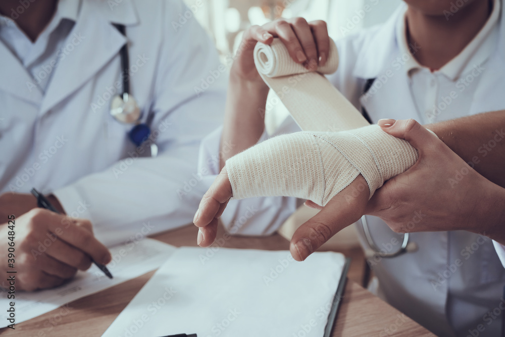 Doctor gently rewinds the man hand. Doctor gently rewinds the man hand.