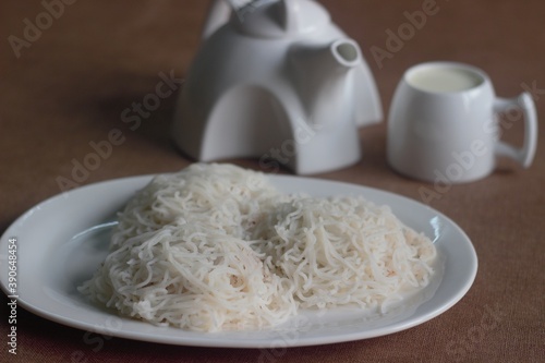 String hopper is a rice noodle dish from Indian states Kerala and Tamil Nadu as well as from Sri Lanka, also known as Idiyappam served with milk and sugar photo
