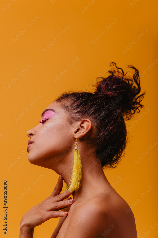 Cute african lady relaxing with eyes closed. Studio close-up shot of beautiful black woman wears yellow earrings. Cute african lady relaxing with eyes closed. Studio close-up shot of beautiful black woman wears yellow earrings.