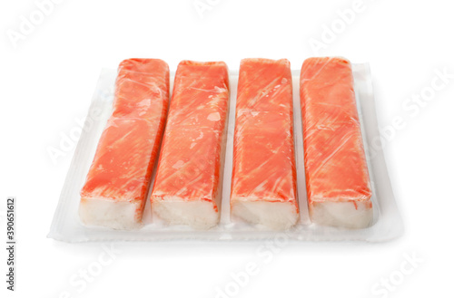 Delicious crab sticks in plastic packaging isolated on white