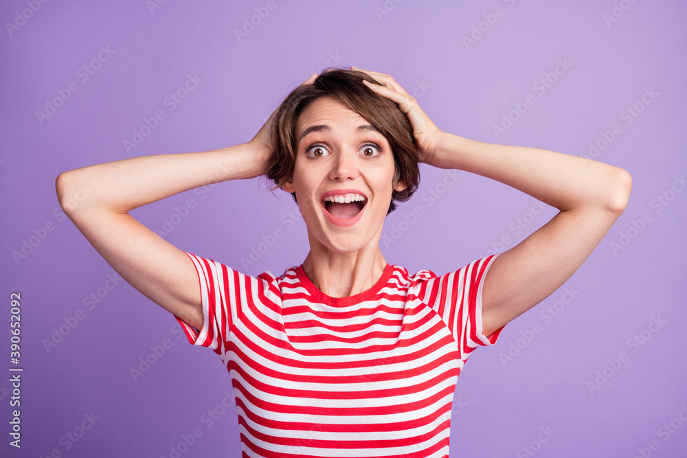Photo of pretty crazy girl open mouth hands head wear striped t-shirt isolated violet color background Photo of pretty crazy girl open mouth hands head wear striped t-shirt isolated violet color background