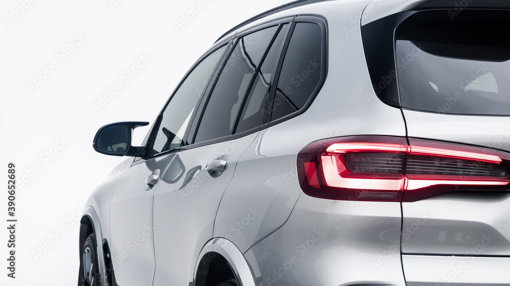 The back of a silver expensive crossover car:  bumper, trunk lid, taillight on the back white background. Mock up for the advertising industry. New car concept