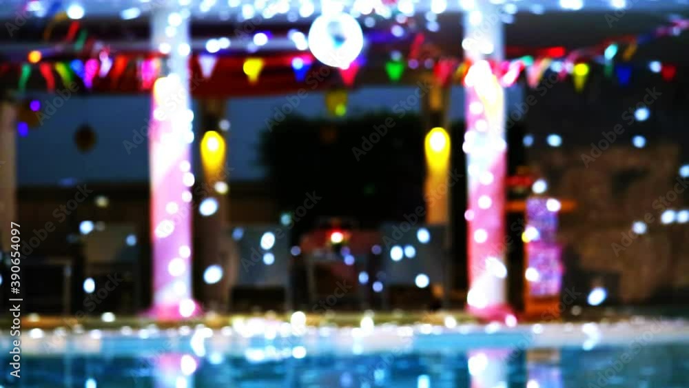 Reflection Blurred and bokeh dancing blue lights of party at luxury pool side Reflection Blurred and bokeh dancing blue lights of party at luxury pool side