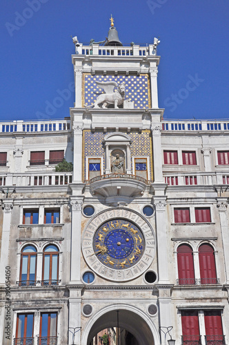 The distinctive clock and winged Lion of Venice adorn the resplendent front of St Mark's Basilica in Venice.