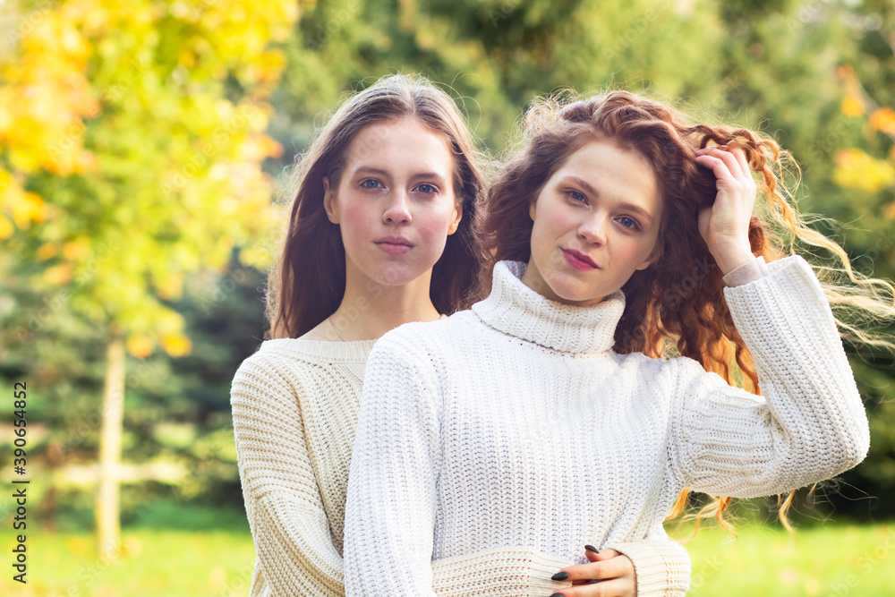 Homosexual couple, two young lesbian women hugging in the park outdoors. Sisters for a walk. Homosexual couple, two young lesbian women hugging in the park outdoors. Sisters for a walk.