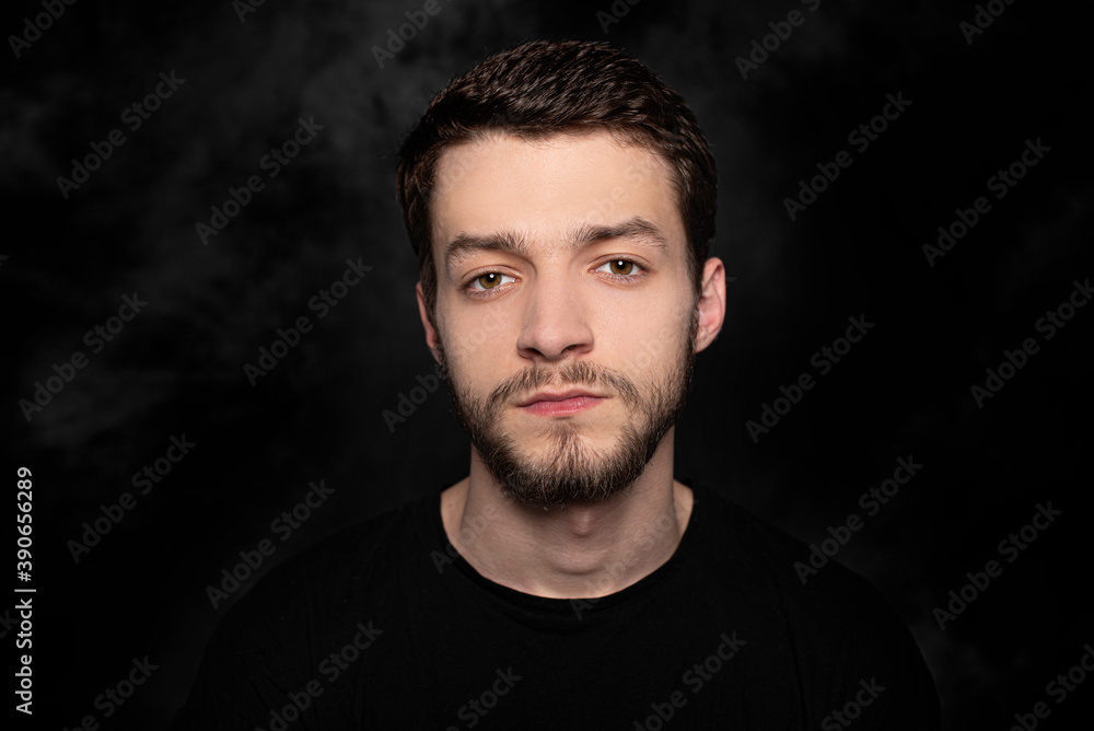 Portrait of a young man on a dark background.