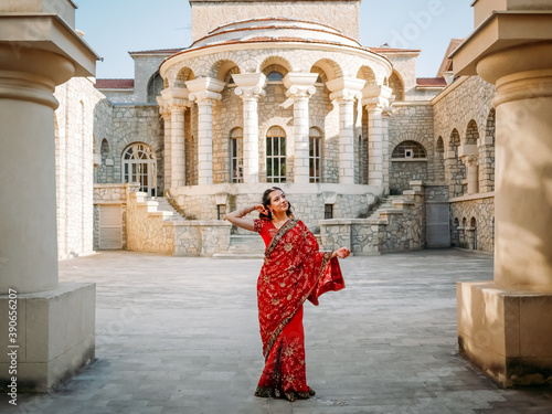 Beautiful ethnic Indian Saree. Young woman in red, colorful, sensual, wedding and very feminine outfit - Indian sari poses on old streets in India. .Traditional national clothing of Indian women