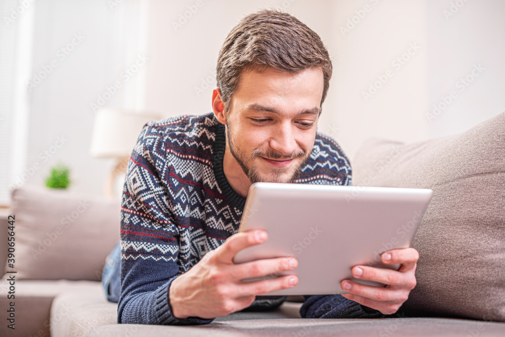 Young man using tablet pc on the couch Young man using tablet pc on the couch