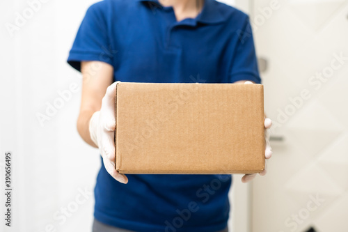 Delivery man holding cardboard boxes in medical rubber gloves and mask. copy space. Fast and free Delivery transport . Online shopping and Express delivery . Quarantine