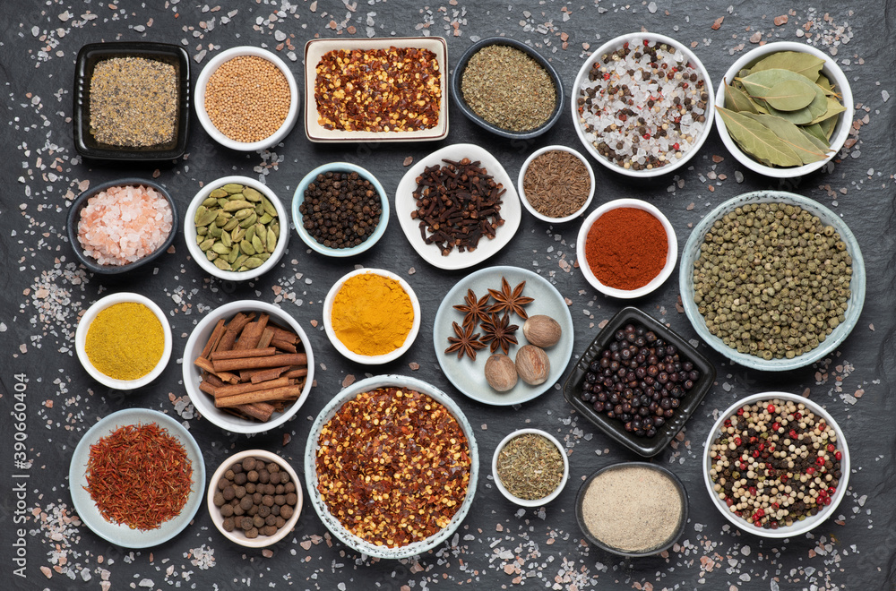 Assortment of aromatic spices and herbs in small bowls 