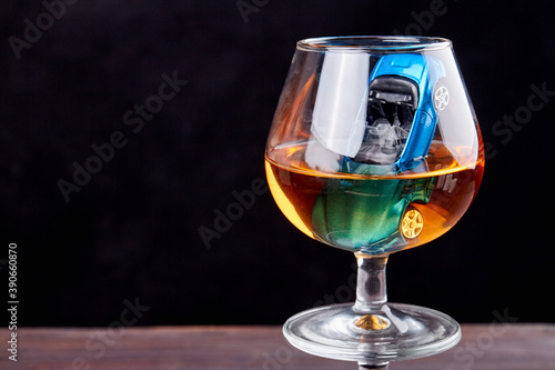 Fotografie Composition with miniature car in a glass of whiskey