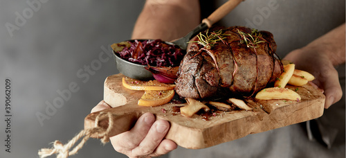 Chef holding a serving of roasted wild venison photo