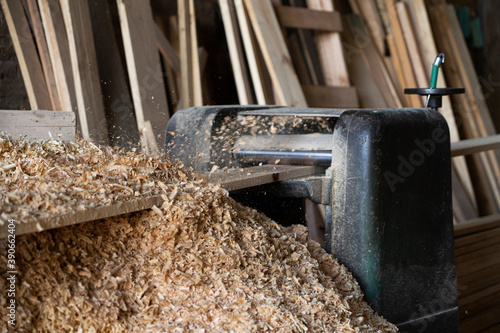 working at Wood planing machine working. Sawmill, business and wood factory for construction. Heavy machine planing wood. Mountains of sawdust.