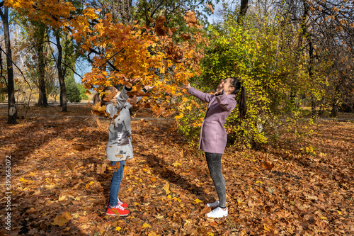 mother and daughter having fun in the autumn park