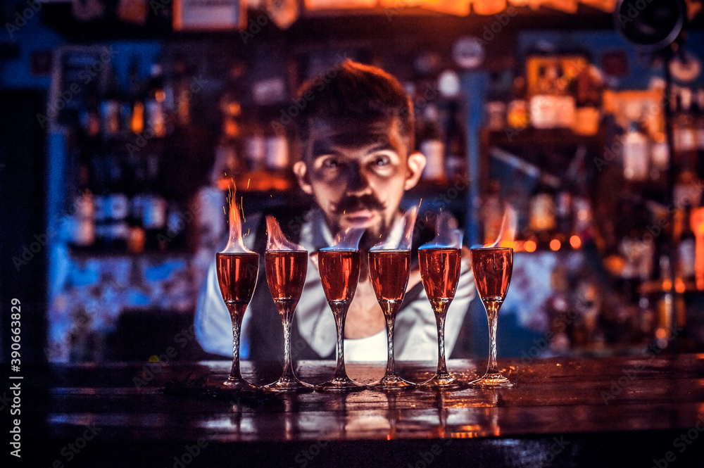 Focused mixologist demonstrates the process of making a cocktail in cocktail bars