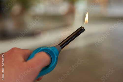Aktiviertes Feuerzeug mit kleiner Flamme in Hand