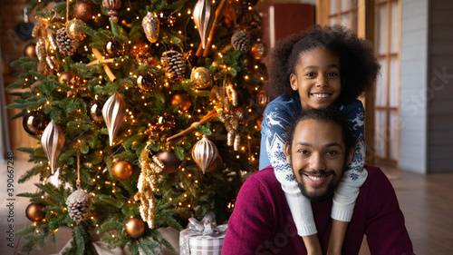 Bild auf Leinwand Head shot portrait smiling African American adorable girl hugging father from ba