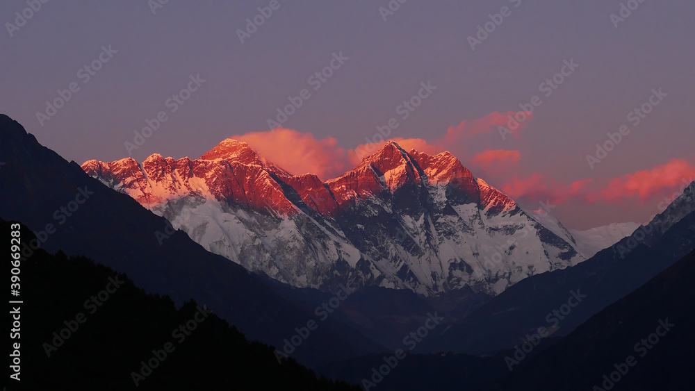 Stunning panorama view of mighty Mount Everest massif illuminated by the red colored evening light at sunset viewed from Sherpa village Namche Bazar in Sagarmatha National Park, Himalayas, Nepal.